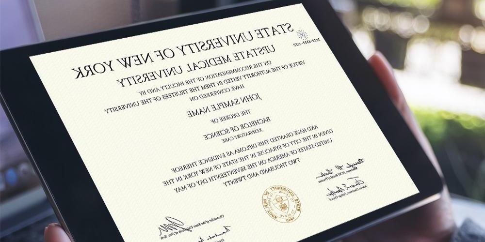 A person holding a tablet with their diploma displayed
